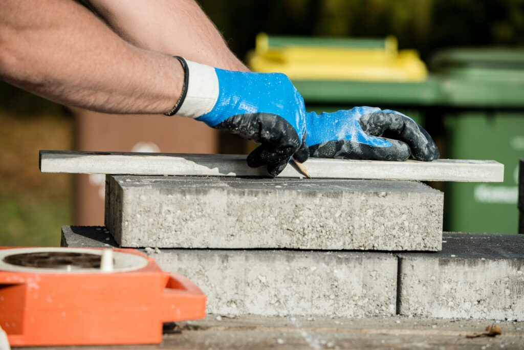 Builder marking a paving stone or block to cut